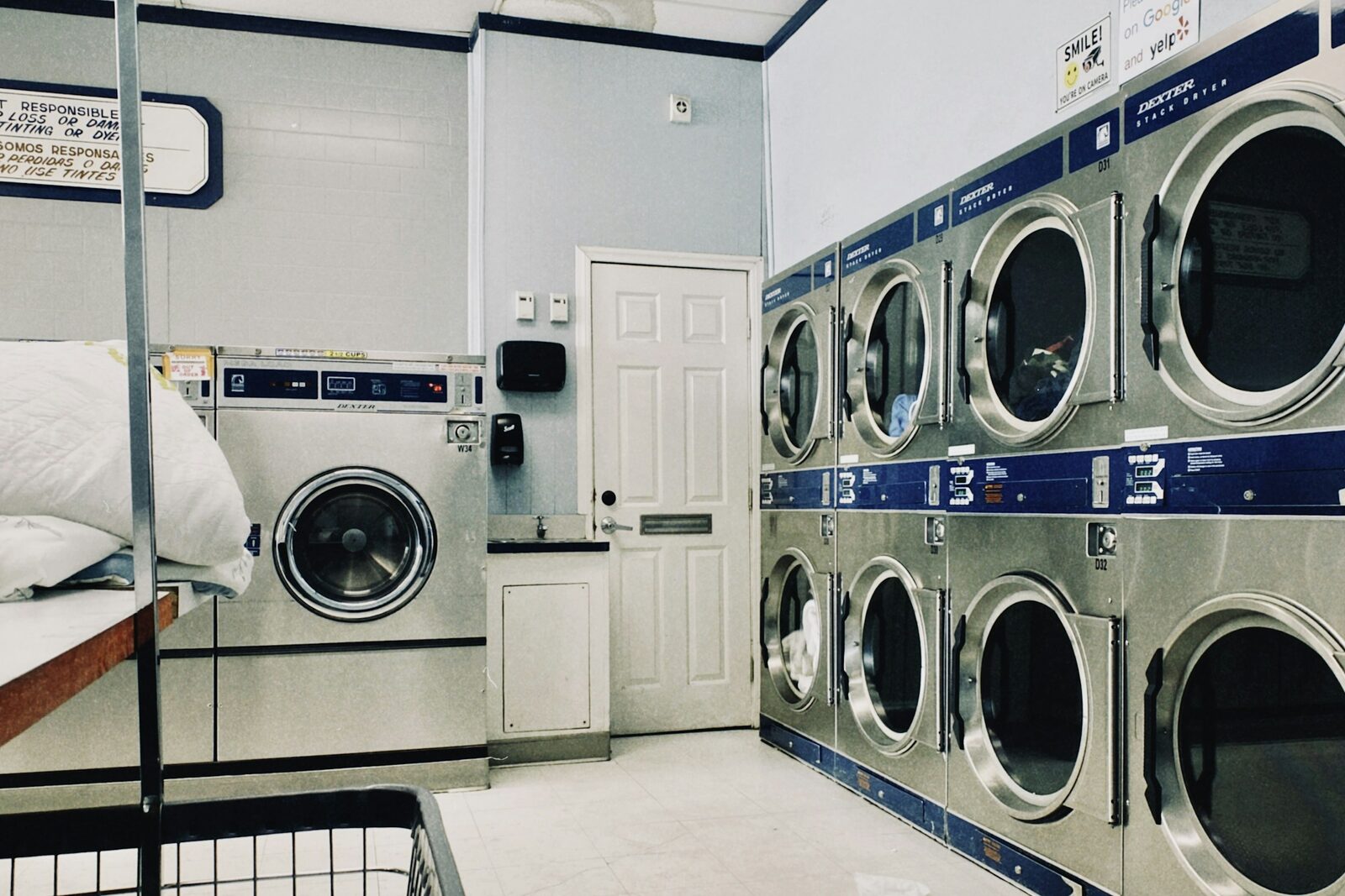 A row of front-loading washing machines and tumble dryers